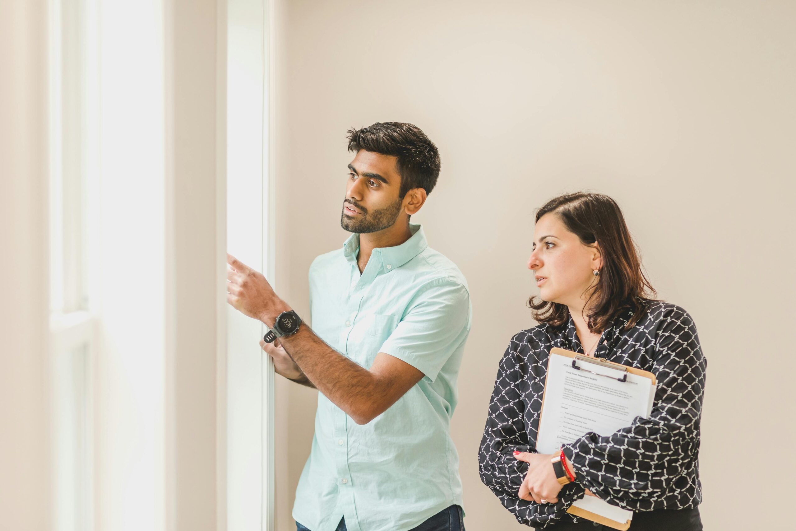 Realtor showing a property to a client indoors, discussing details.